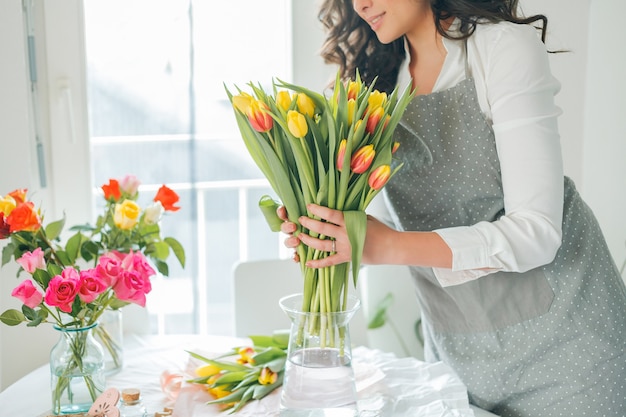 Florista jovem coleta um buquê de flores. feriados. presentes. buquê de tulipas.