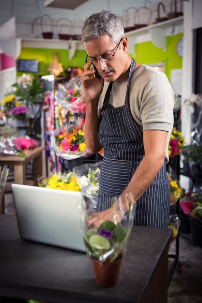 Foto florista masculina, levando a ordem no laptop