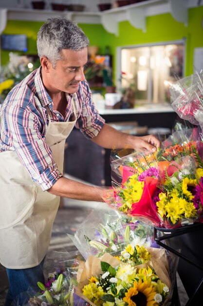 Florista masculina, organizando o buquê de flores