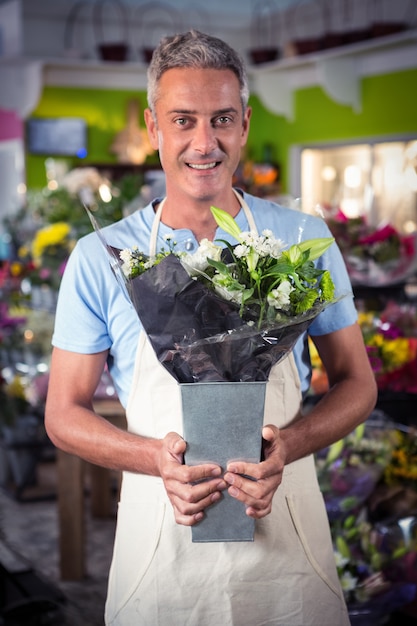 Florista masculina segurando o buquê de flores na loja de flores