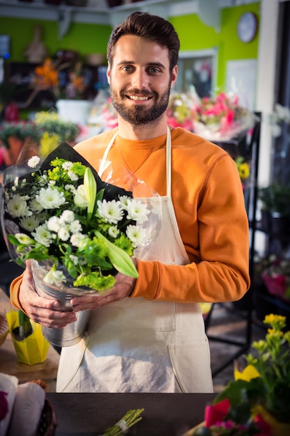 Florista masculina segurando o buquê de flores na loja de flores