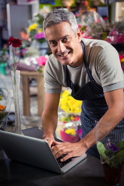 Florista masculina usando laptop