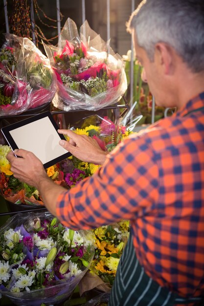 Foto florista masculino tomando foto de ramo de flores