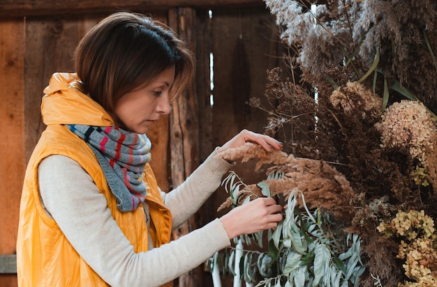 Florista de moda decora la composición con flores secas