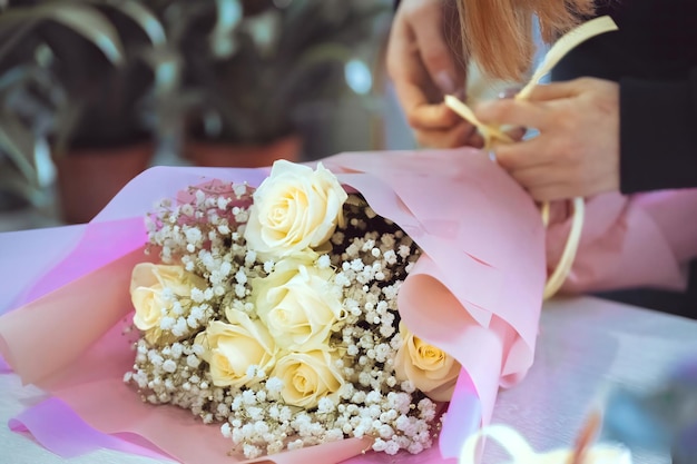 Florista no trabalho mulher fazendo buquê de moda de flores rosas