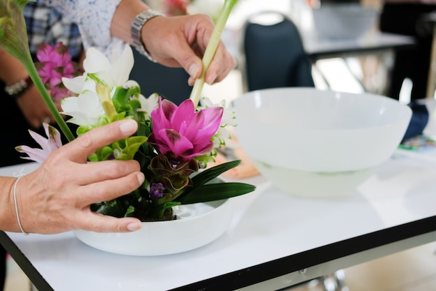 Florista, organizando o buquê de flores em um vaso.