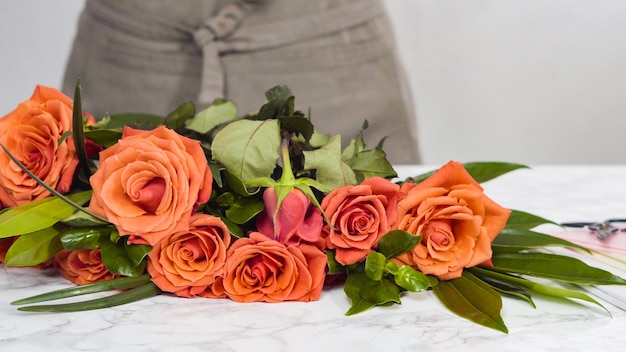 Florista poda de rosas vermelhas para arranjo de buquê.