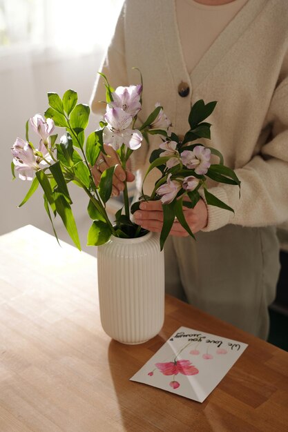 Florista poniendo un ramo de flores en un jarrón