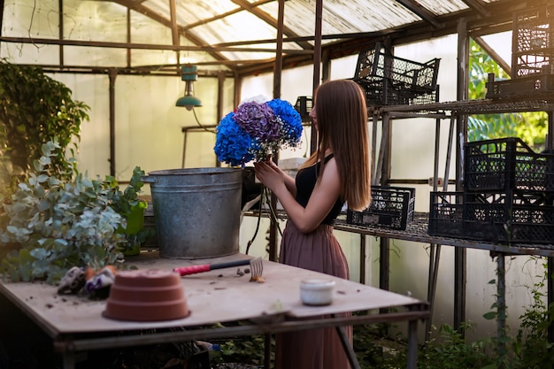 una florista prepara un ramo de hortensias en un hermoso jardín