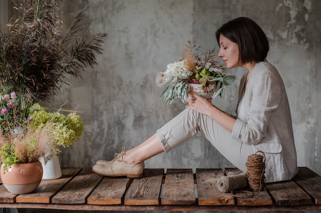 Florista profissional feminina prepara o arranjo de flores silvestres.