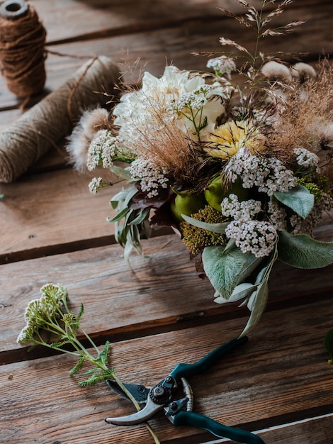 Foto florista profissional feminina prepara o arranjo de flores silvestres.