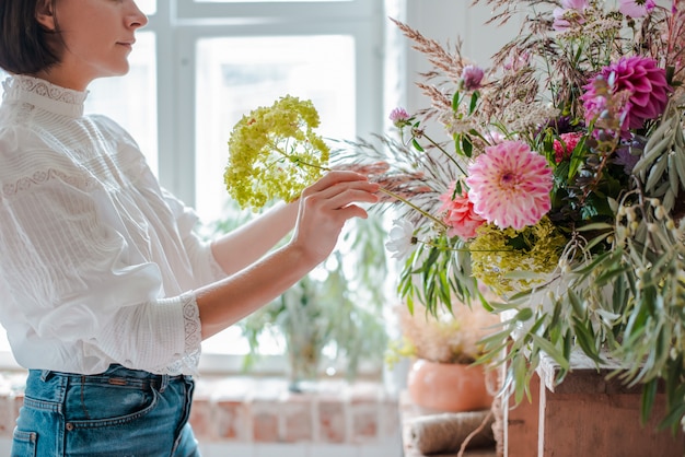 Florista profissional feminina prepara o arranjo de flores silvestres.