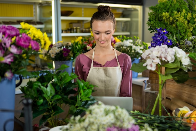 Florista usando laptop em floricultura