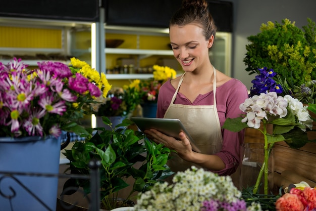 Florista usando tablet digital em floricultura