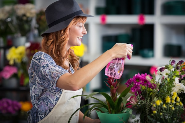 Floristen sprühen Wasser auf Blumen im Blumenladen