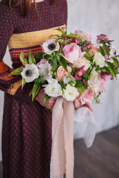 Floristería femenina con ramo floral floreciente recién hecho