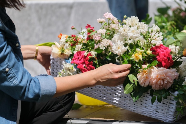 Floristería femenina trabajando con flores al aire libre decorando eventos con flores.
