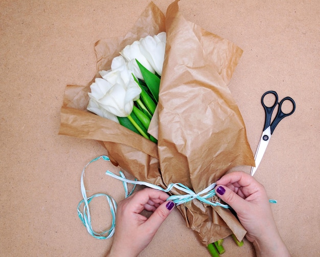 Floristería hace un ramo de tulipanes blancos