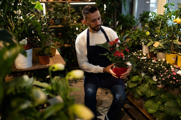 Floristería jardinero rodeada de plantas en macetas y flores naturales.