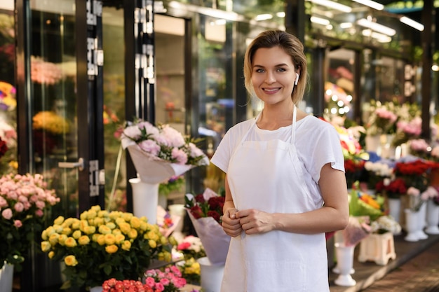 Floristería joven y bella mujer trabajando en su pequeña florería