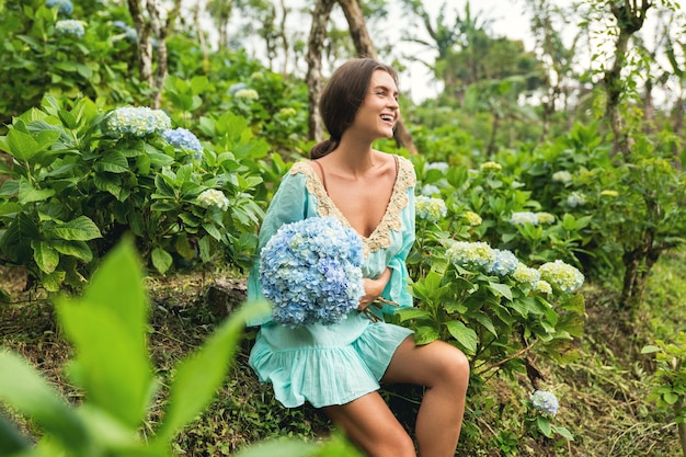 Floristería joven y hermosa recogiendo flores de Hortensia en el campo