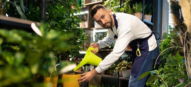 Floristería masculina en el trabajo en una floristería