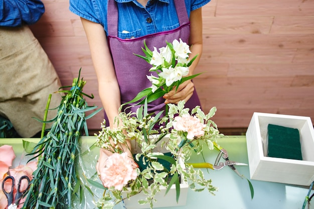 Floristería niña crea un ramo de flores en el estudio