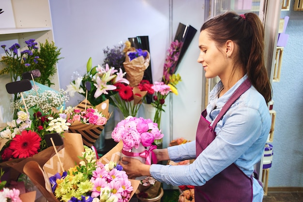 Foto floristería niña crea un ramo de flores en el estudio