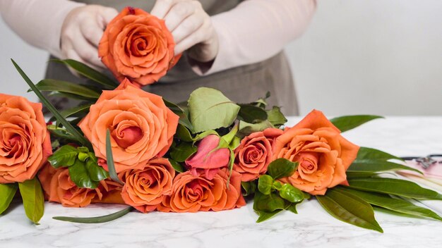 Floristería podando rosas rojas para arreglos de ramo.