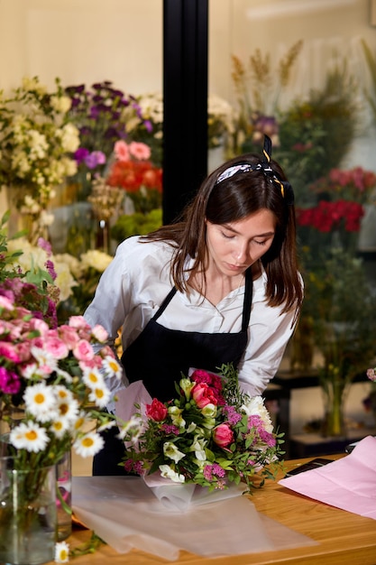 Foto floristería profesional trabaja con colores. vendedor de flores elige flores para el futuro ramo