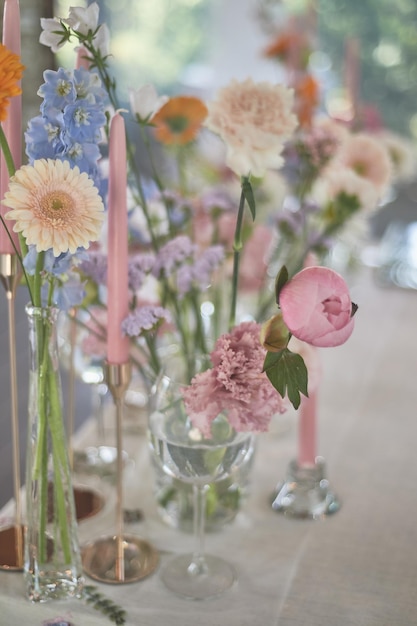 Foto florística decoración floral de la boda en colores pastel muchas flores en diferentes jarrones y vasijas