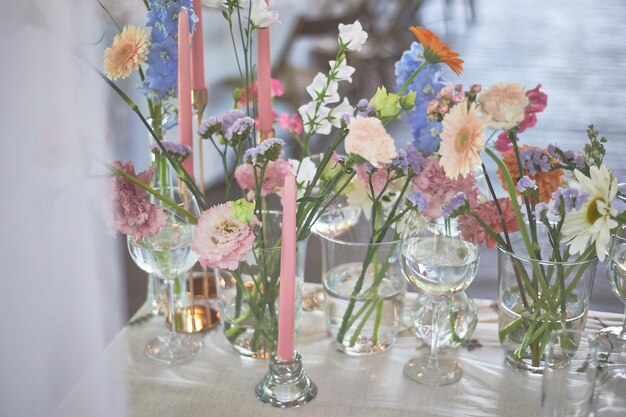 Foto florística decoración floral de la boda en colores pastel muchas flores en diferentes jarrones y vasijas