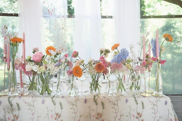 Foto florística decoración floral de la boda en colores pastel muchas flores en diferentes jarrones y vasijas
