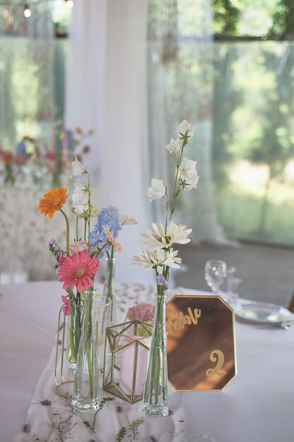 Foto florística decoración floral de la boda en colores pastel muchas flores en diferentes jarrones y vasijas