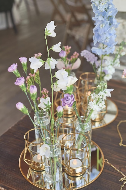 Foto florística decoración floral de la boda en colores pastel muchas flores en diferentes jarrones y vasijas
