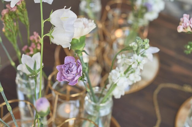 Foto florística decoración floral de la boda en colores pastel muchas flores en diferentes jarrones y vasijas