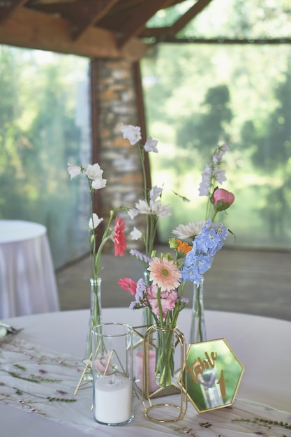 Foto floristik blumendekoration zur hochzeit in pastellfarben viele blumen in verschiedenen vasen und gefäßen