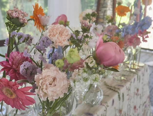 Floristik Blumendekoration zur Hochzeit in Pastellfarben Viele Blumen in verschiedenen Vasen und Gefäßen