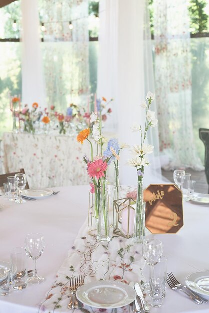 Foto floristik blumendekoration zur hochzeit in pastellfarben viele blumen in verschiedenen vasen und gefäßen