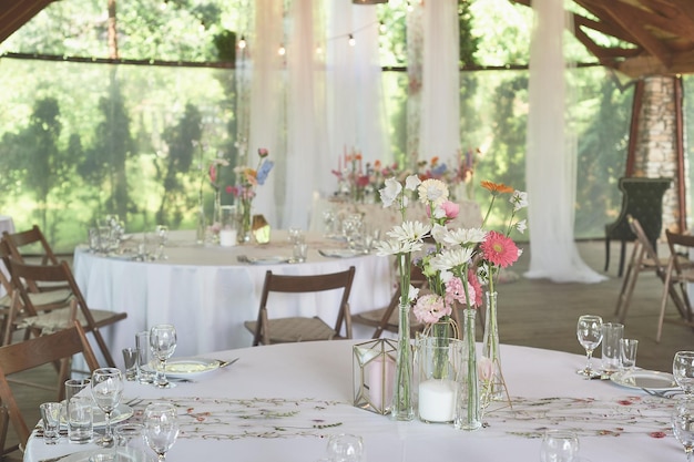 Foto floristik blumendekoration zur hochzeit in pastellfarben viele blumen in verschiedenen vasen und gefäßen