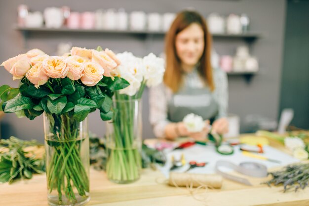 Floristin bereitet Rosenstrauß am Arbeitsplatz vor