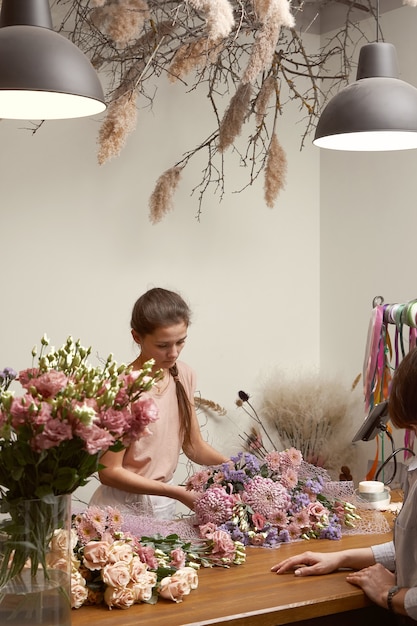 Floristin der jungen Frau in ihrem Studio, das einen schönen Blumenstrauß macht