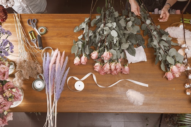 Floristin der jungen Frauen in ihrem Studio, das einen schönen Blumenstrauß macht. Draufsicht