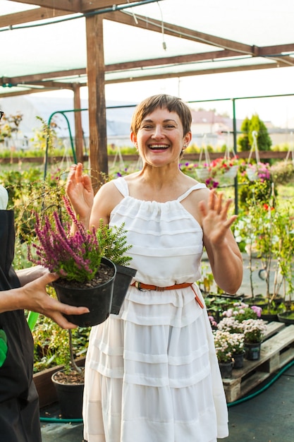 Floristin, die dem Kunden im Blumenladen Blumen zeigt