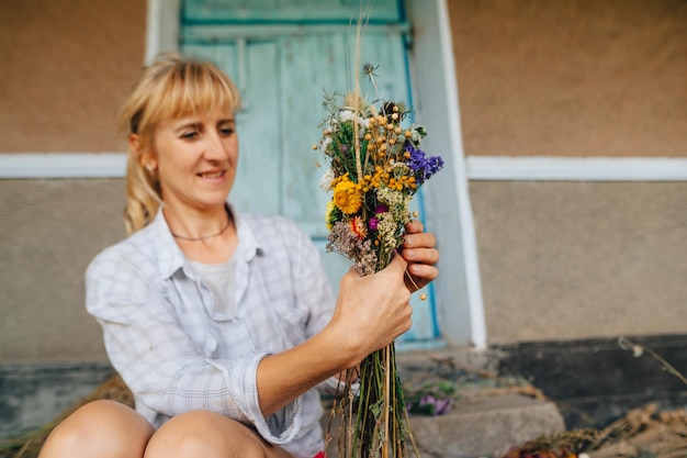 Floristin für Erwachsene kreiert einen schönen Strauß getrockneter Blumen