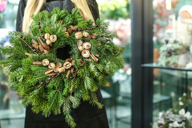 Floristin mit Weihnachtskranz im Blumenladen