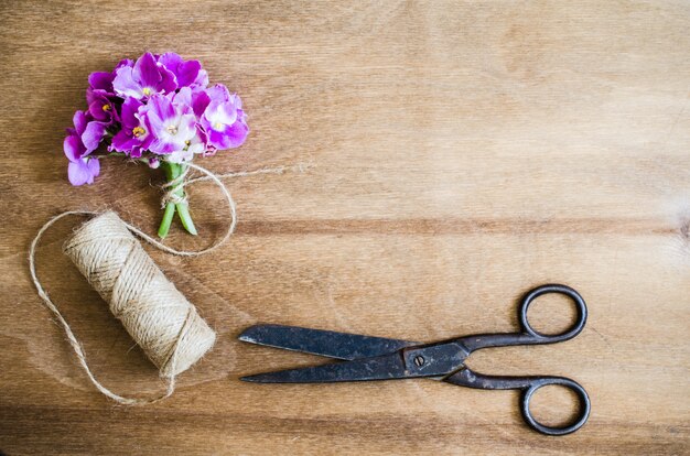 Floristischer Hintergrund. Blumen, Schere und Seil.