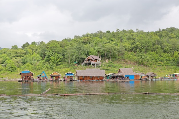 Floss-Haus, das auf den Fluss mit Berg hinten schwimmt.