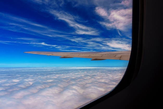 Flügel des Flugzeugs, das über den Wolken am Himmel fliegt
