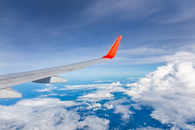 Flügel des Flugzeugs mit blauem Himmel und Wolken